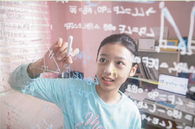 유리 칠판에 수식을 쓰며 개념을 설명하는 학생